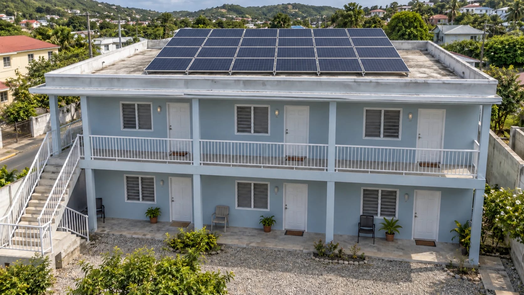 Small guesthouse with separate room entrances and twenty-four rooftop solar panels; illustrative installation scene